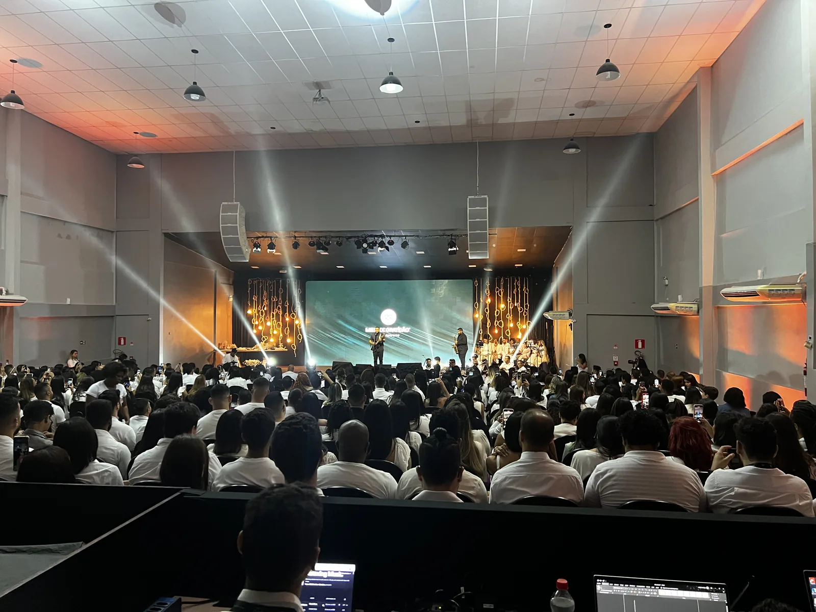 Plateia de convenção corporativa sob feixes de luz